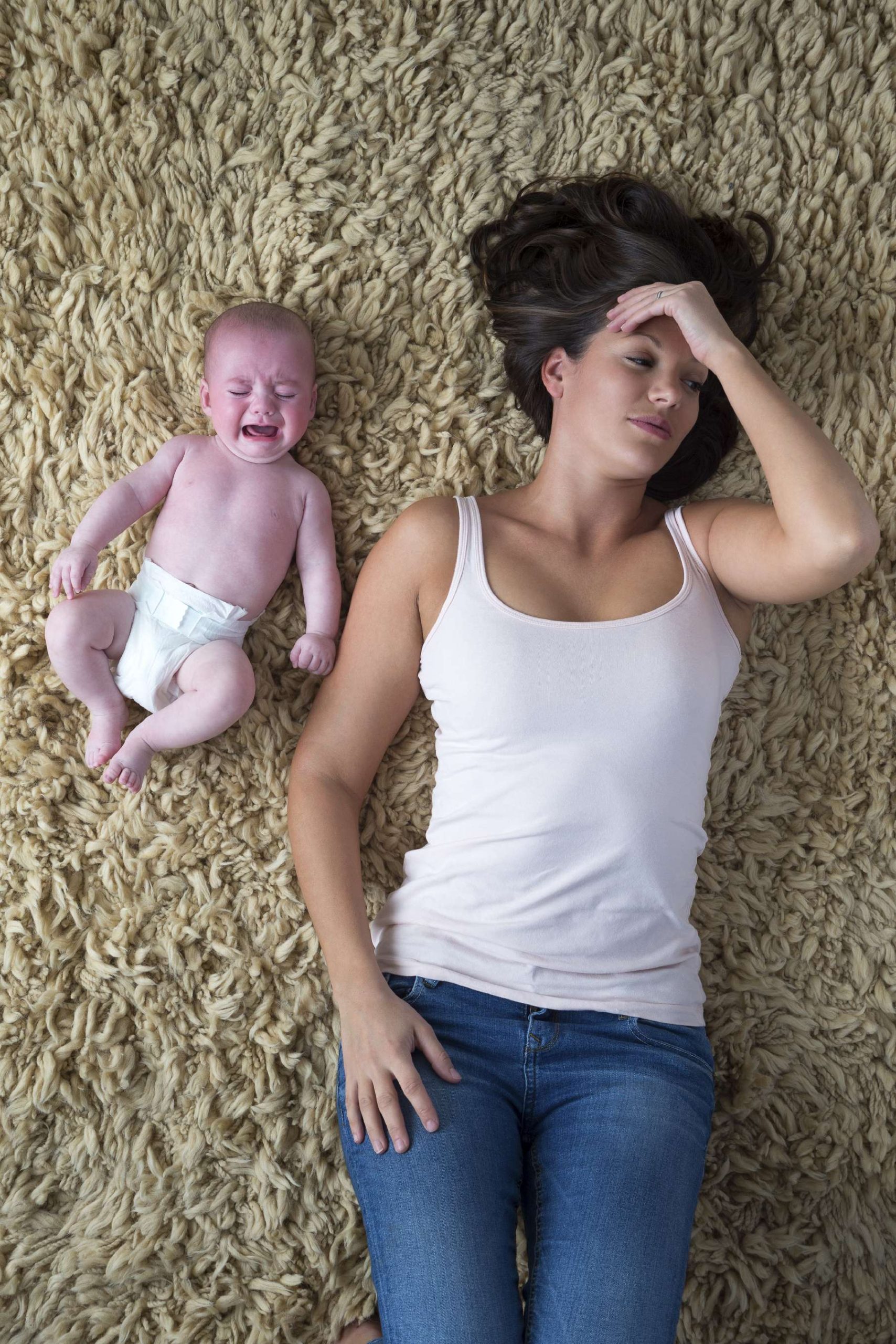 Stressed Mom Lying Next to Crying Baby