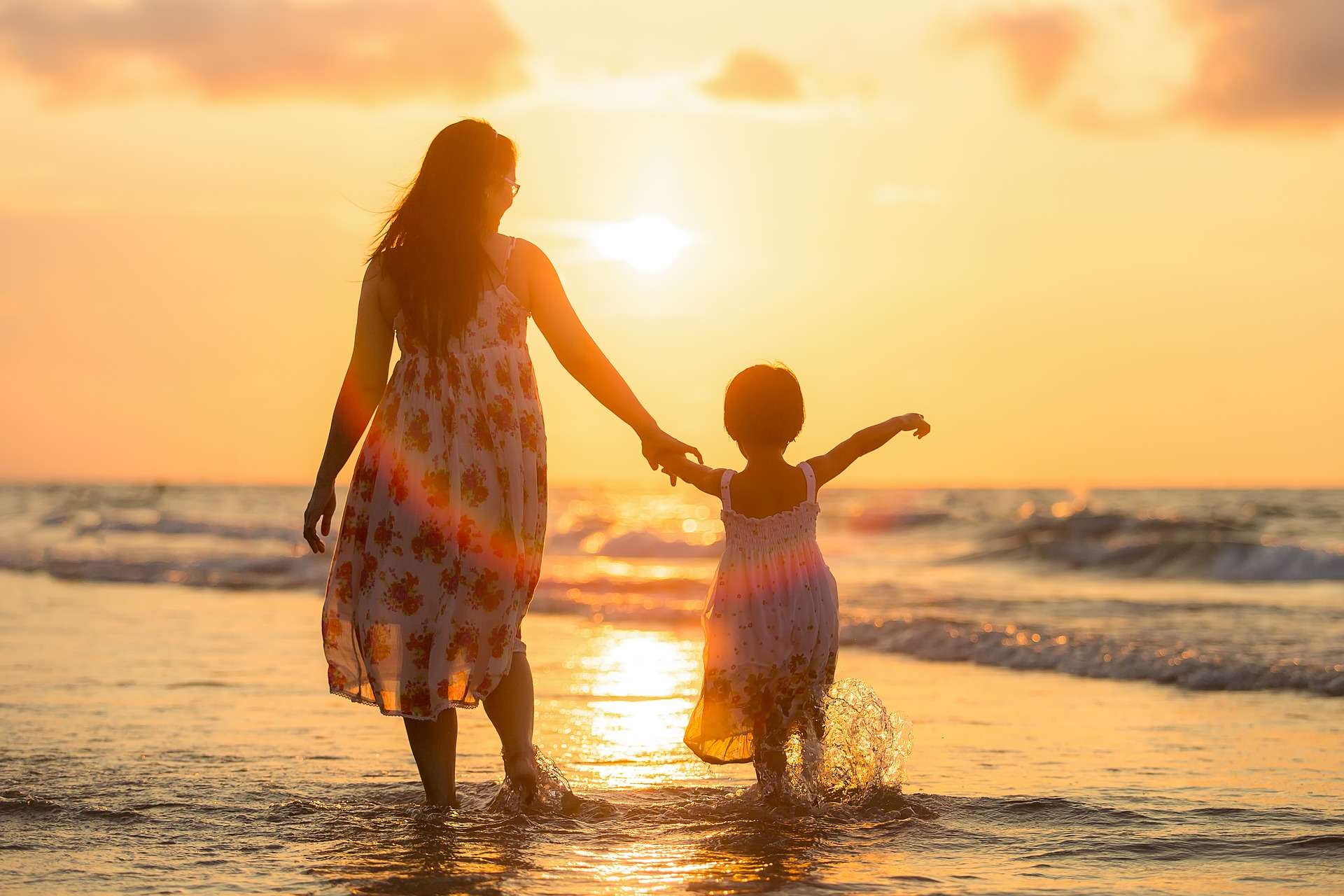 Woman Walking With Toddler on Sunset Beach