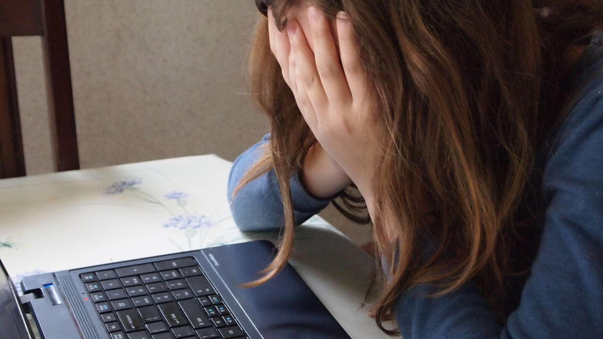 Person in Despair Leaning on Laptop Computer